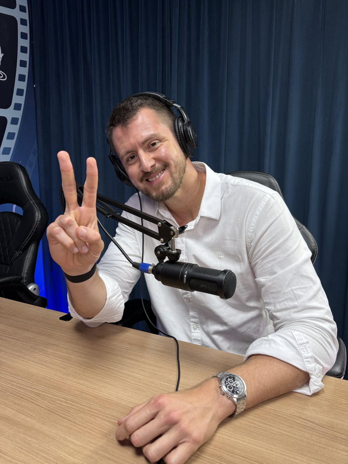 Luiz Antonio sorrindo em um estúdio de podcast